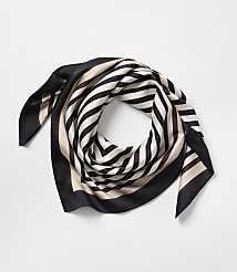 A silk scarf with black, white, and tan stripes is artfully folded on a plain white background. carousel Product Image 1