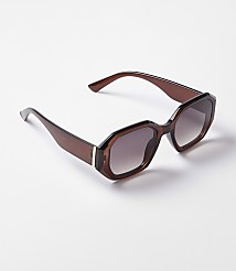 A pair of brown, hexagonal-shaped sunglasses with gradient lenses rests on a plain white background. carousel Product Image 1