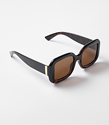 A pair of tortoiseshell sunglasses with brown lenses rests on a plain white background. carousel Product Image 1