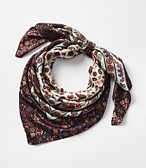 A patterned silk scarf with paisley and floral designs is tied in a knot against a plain white background. carousel Product Image 1