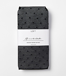 A pair of black sheer polka dot tights are neatly folded with a white band around them, set against a plain white background. carousel Product Image 1