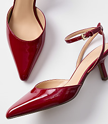 A pair of shiny red patent leather slingback heels with pointed toes and ankle straps are displayed against a plain white background. carousel Product Image 2