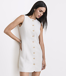 A woman in a sleeveless white dress with gold buttons stands against a plain white background. carousel Product Image 2