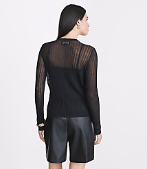 A woman in a sheer black sweater and leather shorts stands against a plain white background. carousel Product Image 3