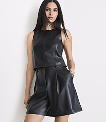 A woman in a black leather top and shorts stands against a plain white background. carousel Product Image 2