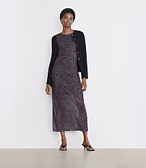 A woman in a leopard print dress and black cardigan stands against a plain white background. carousel Product Image 1
