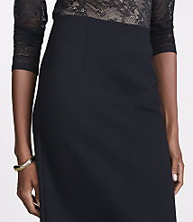 A woman in a black lace top and skirt, adorned with a gold bracelet, stands against a plain background. carousel Product Image 4