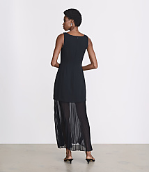 A woman in a black dress with a pleated skirt stands against a plain white background. carousel Product Image 3