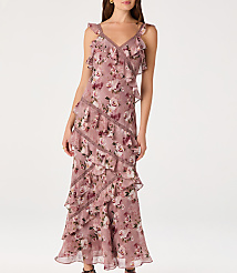 A woman in a ruffled, floral-print dress stands against a plain white background. carousel Product Image 1