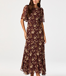 A woman in a floral dress stands against a plain white background. carousel Product Image 1
