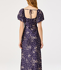 A woman in a dark blue floral and polka dot dress stands against a plain white background. carousel Product Image 2