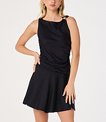 A woman in a black dress with gold accents stands against a plain white background. carousel Product Image 1