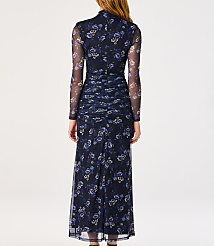 A woman in a long, dark blue floral mesh dress stands against a plain white background. carousel Product Image 2