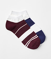 Two ankle socks, one white with a football emblem and the other beige with a bow, are arranged against a plain white background. carousel Product Image 1