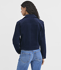 A woman in a navy corduroy jacket and blue jeans stands against a plain white background. carousel Product Image 3