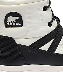 A close-up of a white quilted Sorel boot with a black sole and laces is shown against a plain white background. carousel Product Image 6