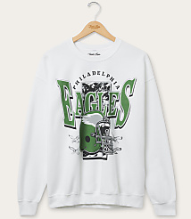 A white sweatshirt with a Philadelphia Eagles graphic featuring a helmet and lettering is displayed on a hanger against a plain white background. carousel Product Image 1