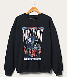 A dark blue New York Giants sweatshirt with a graphic of a helmet and team name is displayed on a wooden hanger against a plain, light-colored background. carousel Product Image 1