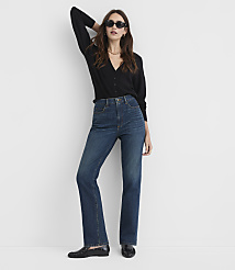 A woman in a black cardigan and flared jeans poses against a plain white background. carousel Product Image 1