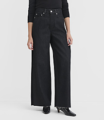 A person stands in dark wash wide-leg jeans with frayed hems and black heeled boots against a plain white background. carousel Product Image 1