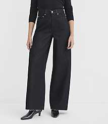 A person stands in dark, wide-leg jeans and black heels against a plain white background. carousel Product Image 2