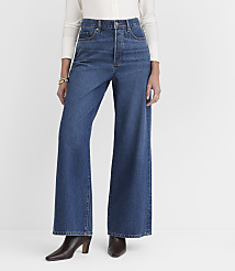 A person stands in wide-leg blue jeans and brown heeled boots against a plain white background. carousel Product Image 2