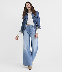 A woman in a denim jacket and wide-leg jeans stands against a plain white background. carousel Product Image 1