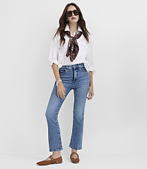 A woman in a white shirt, blue jeans, and brown flats stands against a plain white background. carousel Product Image 1