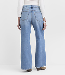 A person wearing light blue wide-leg jeans and a white long-sleeved shirt stands against a plain white background. carousel Product Image 2
