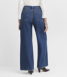 A person wearing wide-leg blue jeans and brown heeled boots stands against a plain white background. carousel Product Image 2