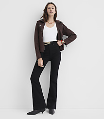 A woman in a white top, brown jacket, and black flared jeans stands against a plain white background. carousel Product Image 1
