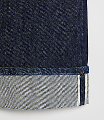 A close-up of dark denim jeans with a cuffed hem, set against a plain white background. carousel Product Image 5