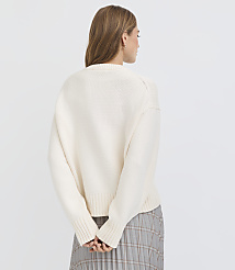 A woman in a cream-colored sweater and plaid skirt stands with her back to the camera against a plain white background. carousel Product Image 4