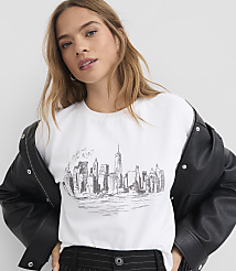 A woman in a white t-shirt with a New York City skyline sketch on it, wearing a black leather jacket, is shown against a plain background. carousel Product Image 1