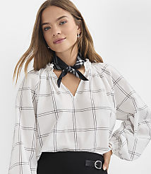 A woman in a white checkered blouse and black scarf poses against a plain white background. carousel Product Image 1