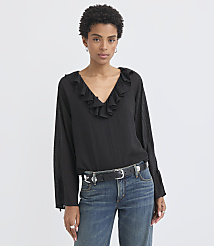 A woman in a black ruffled blouse and jeans stands against a plain white background. carousel Product Image 2