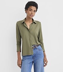 A woman in a green collared shirt and blue jeans stands against a plain white background. carousel Product Image 1