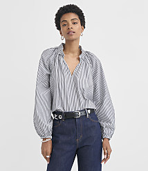 A woman in a striped blouse and jeans stands against a plain white background. carousel Product Image 1