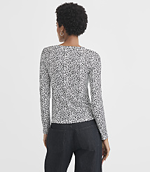 A woman in a dalmatian-print long-sleeved shirt and dark jeans stands against a plain white background. carousel Product Image 3