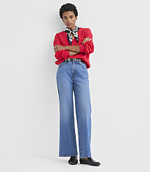 A woman in a red sweatshirt and wide-leg jeans stands with her arms crossed against a plain white background. carousel Product Image 2