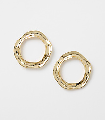 Two irregular, hammered gold hoop earrings rest on a plain white background. carousel Product Image 1