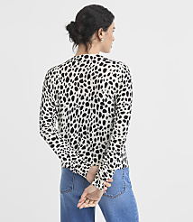 A woman in a dalmatian-print sweater and blue jeans stands with her back to the camera against a plain white background. carousel Product Image 3