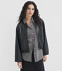 A woman in a black leather jacket and striped shirt stands against a plain white background. carousel Product Image 1