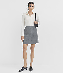 A woman in a white blouse and plaid skirt stands against a plain white background. carousel Product Image 1