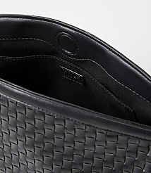 A black woven leather clutch with a snap closure is shown against a plain white background. carousel Product Image 2