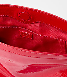 A bright red patent leather clutch with a satin lining and a small interior pocket is presented against a plain white background. carousel Product Image 2