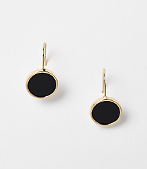 A pair of gold earrings with black circular stones hang against a plain white background. carousel Product Image 1