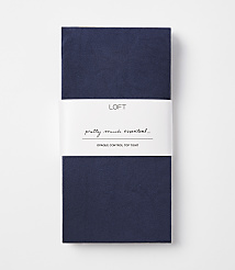 A folded pair of navy blue opaque control top tights with a white band in the middle featuring the "LOFT" logo and text, against a plain white background. carousel Product Image 1