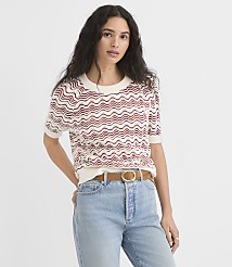 A woman in a patterned sweater and jeans stands against a plain white background. carousel Product Image 1