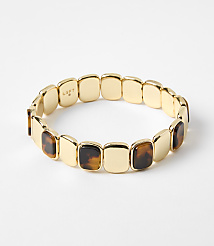 A gold bracelet with square tortoise shell accents rests on a plain white background. carousel Product Image 1